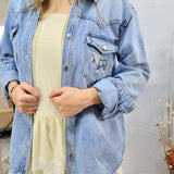 Woman wearing light blue denim shirt with horse embroidery over yellow dress