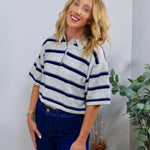 Gray and navy striped cropped rugby polo sweater top with collar, styled with dark blue jeans.