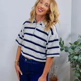 Gray and navy striped cropped rugby polo sweater top with collar, styled with dark blue jeans.