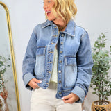 Woman wearing classic blue denim jacket with cropped fit and button front closure