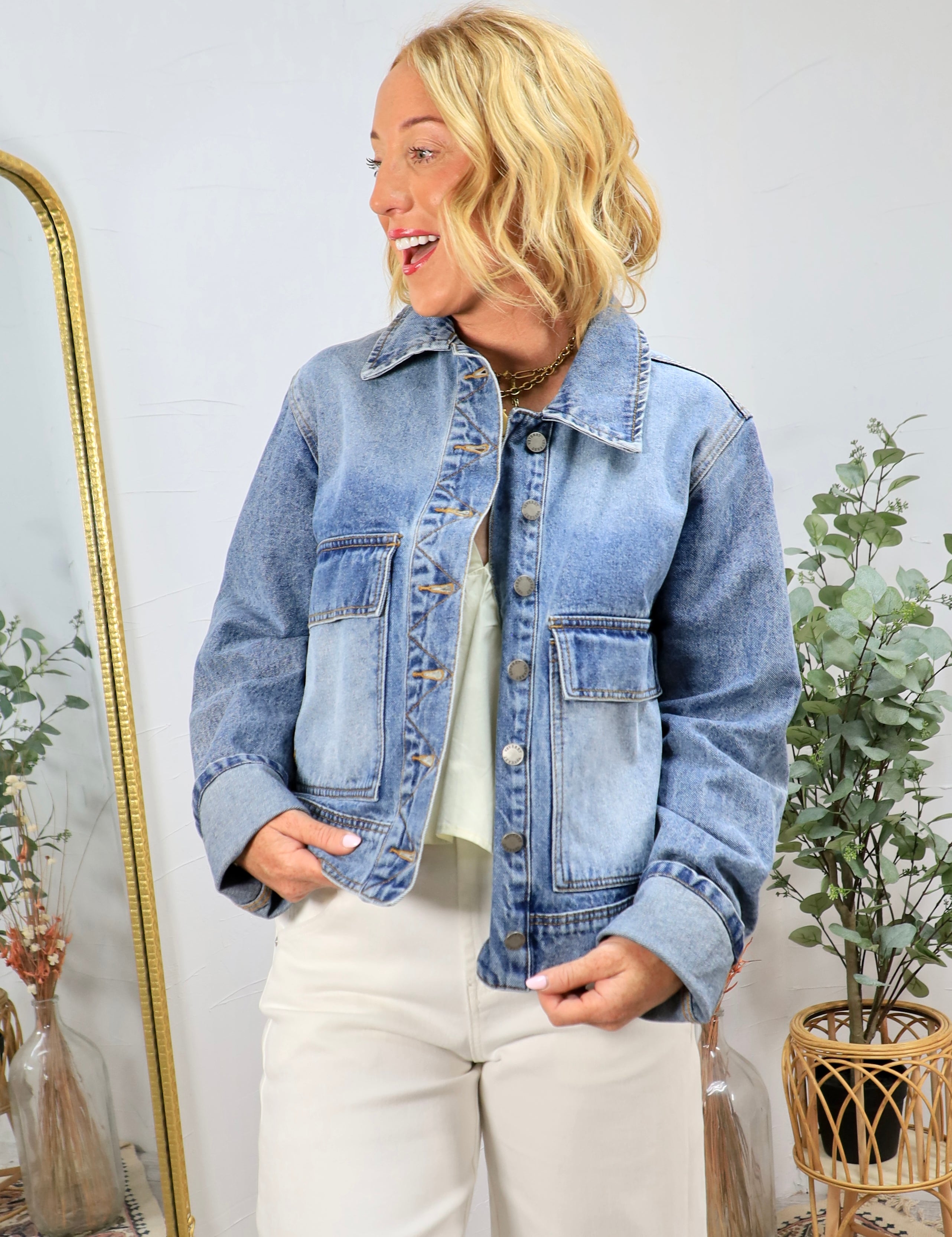 Woman wearing classic blue denim jacket with cropped fit and button front closure