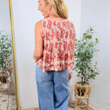 Sleeveless pink floral pleated peplum top styled with wide-leg blue jeans, shown from the back.
