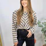 Beige striped long-sleeve Sami Top with chevron pattern, styled with dark navy wide-leg jeans.