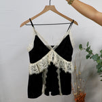 Black spaghetti strap crop top with ivory lace trim and crossover bodice on wooden hanger