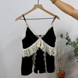 Black spaghetti strap crop top with ivory lace trim and crossover bodice on wooden hanger