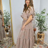 Woman wearing brown and white gingham checkered crop top with puffy sleeves and elastic waistband, styled with matching skirt