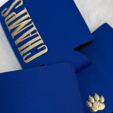 Royal blue neoprene drink koozies with gold "Champs" text and gold paw print logo detail.