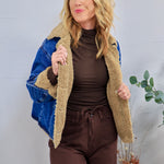 Blue denim jacket with tan sherpa teddy lining, worn open over brown turtleneck and matching brown pants.