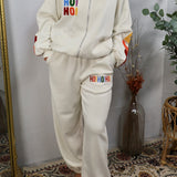 Cream oversized joggers with rainbow embroidered HO HO HO holiday lettering on thigh