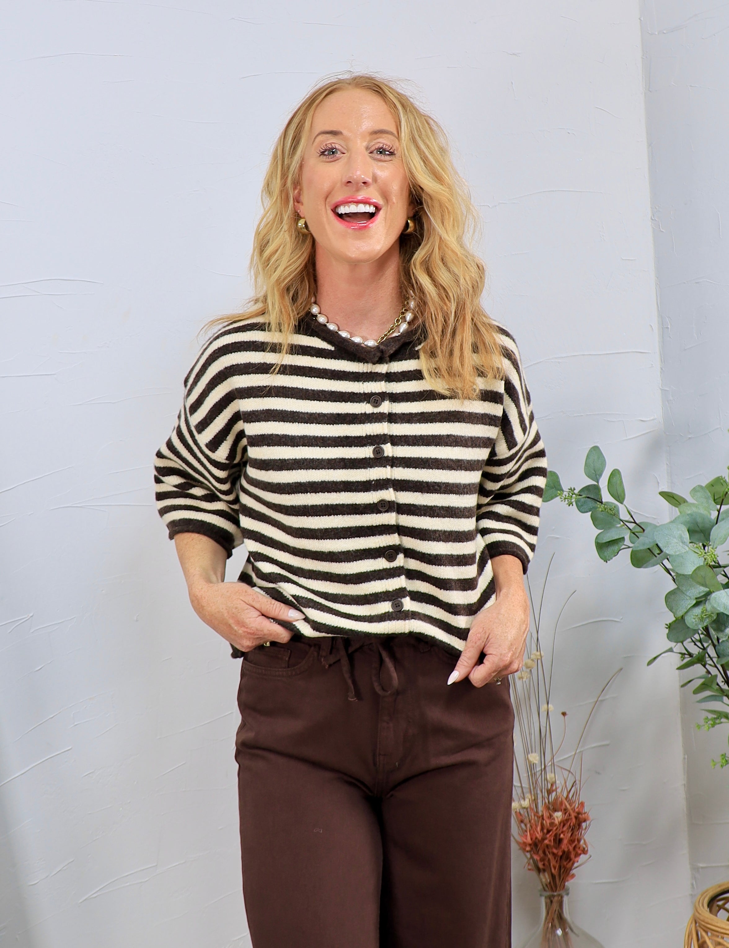 Woman wearing brown and cream striped button-front knit top with 3/4 sleeves, styled with brown wide-leg pants.