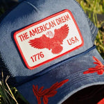 Navy blue trucker hat with red American Dream 1776 USA eagle patch and red floral brim embroidery