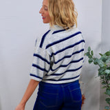 Woman wearing Roy's Rugby Top in gray with navy blue stripes, paired with dark blue high-waisted jeans, back view.