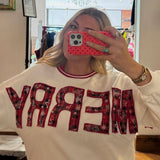 White crewneck sweatshirt with red plaid appliqué "MERRY" lettering, styled with red ribbed neckline trim.