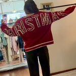 Model wearing red Christmas crewneck sweatshirt with bold festive letter appliqués across the back