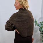 Chocolate brown cropped turtleneck sweater with wide sleeves, paired with a dark brown ribbed midi skirt.