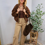 Chocolate brown hooded bomber jacket styled open over brown lace cami and khaki trousers.