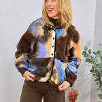 Multicolored sherpa fleece jacket in brown, blue, and orange abstract pattern, styled with dark brown wide-leg pants.
