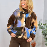 Multicolored sherpa fleece jacket in brown, blue, and orange abstract pattern, styled with dark brown wide-leg pants.