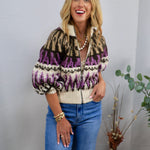 Cream, purple, and black Fair Isle zip-up sweater with puff sleeves, styled with blue jeans and gold jewelry.
