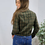 Olive green plaid flannel button-up shirt styled with blue wide-leg jeans, shown from back view.