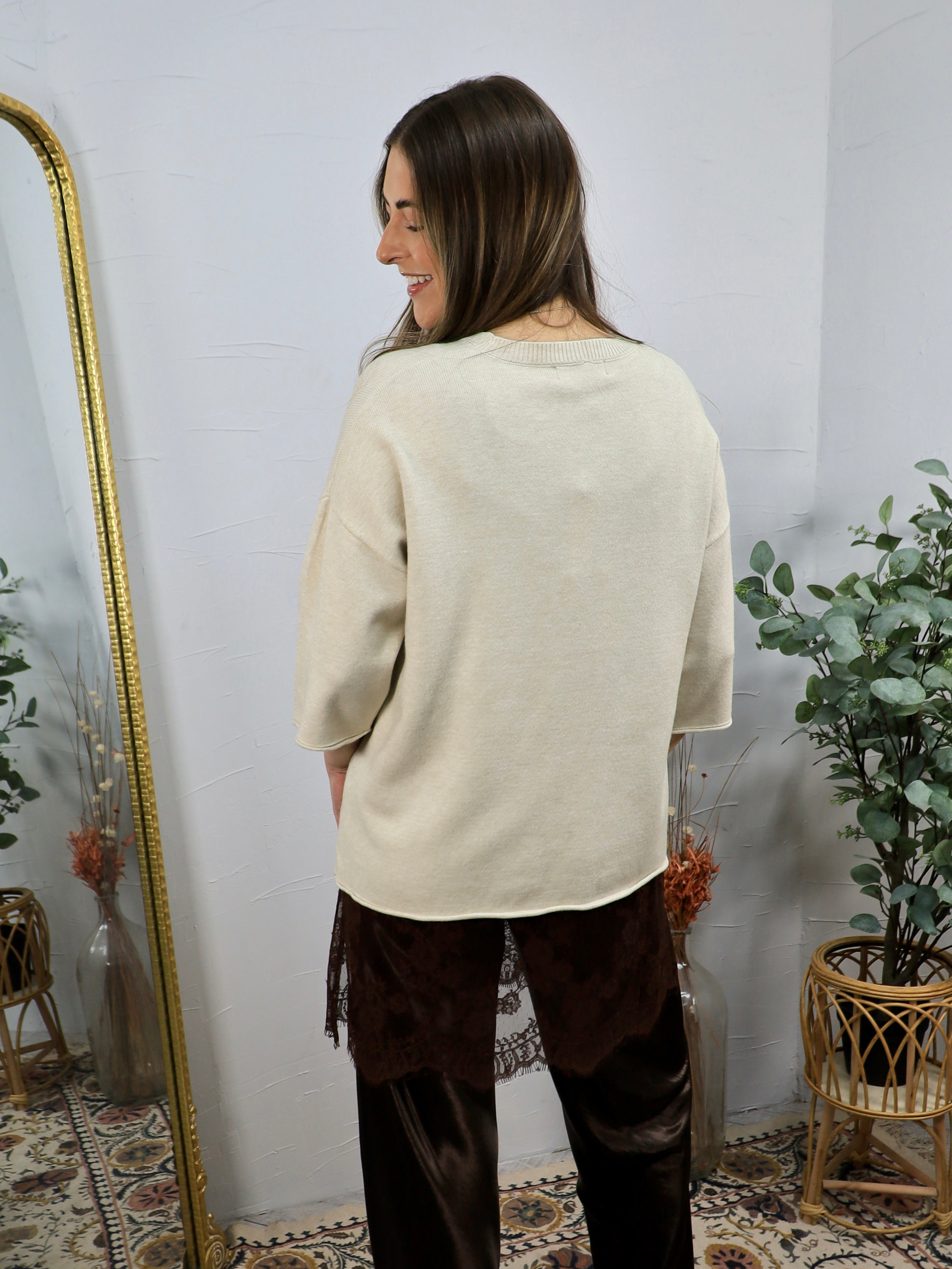 Cream short-sleeve knit sweater shown from behind, paired with dark brown velvet lace-trim trousers.