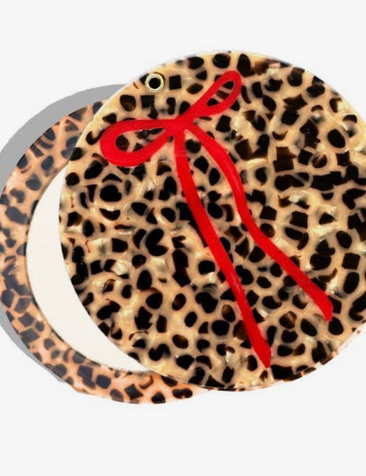Round compact mirror with leopard print tortoiseshell design and decorative red ribbon bow accent.