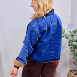 Blue denim Graham Teddy Jacket with tan sherpa lining, collar, and cuffs, styled with brown wide-leg pants.