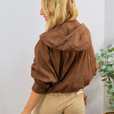 Brown hooded bomber jacket with voluminous sleeves, styled with khaki pants, shown from back angle.