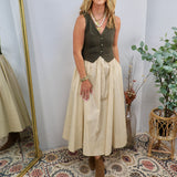 Olive green button-front vest bodice midi dress with cream full skirt, styled with brown ankle boots and layered gold necklac