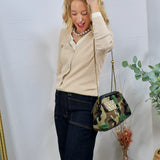 Woman wearing a cream ribbed double-layered button-front top with dark jeans and a camo crossbody bag