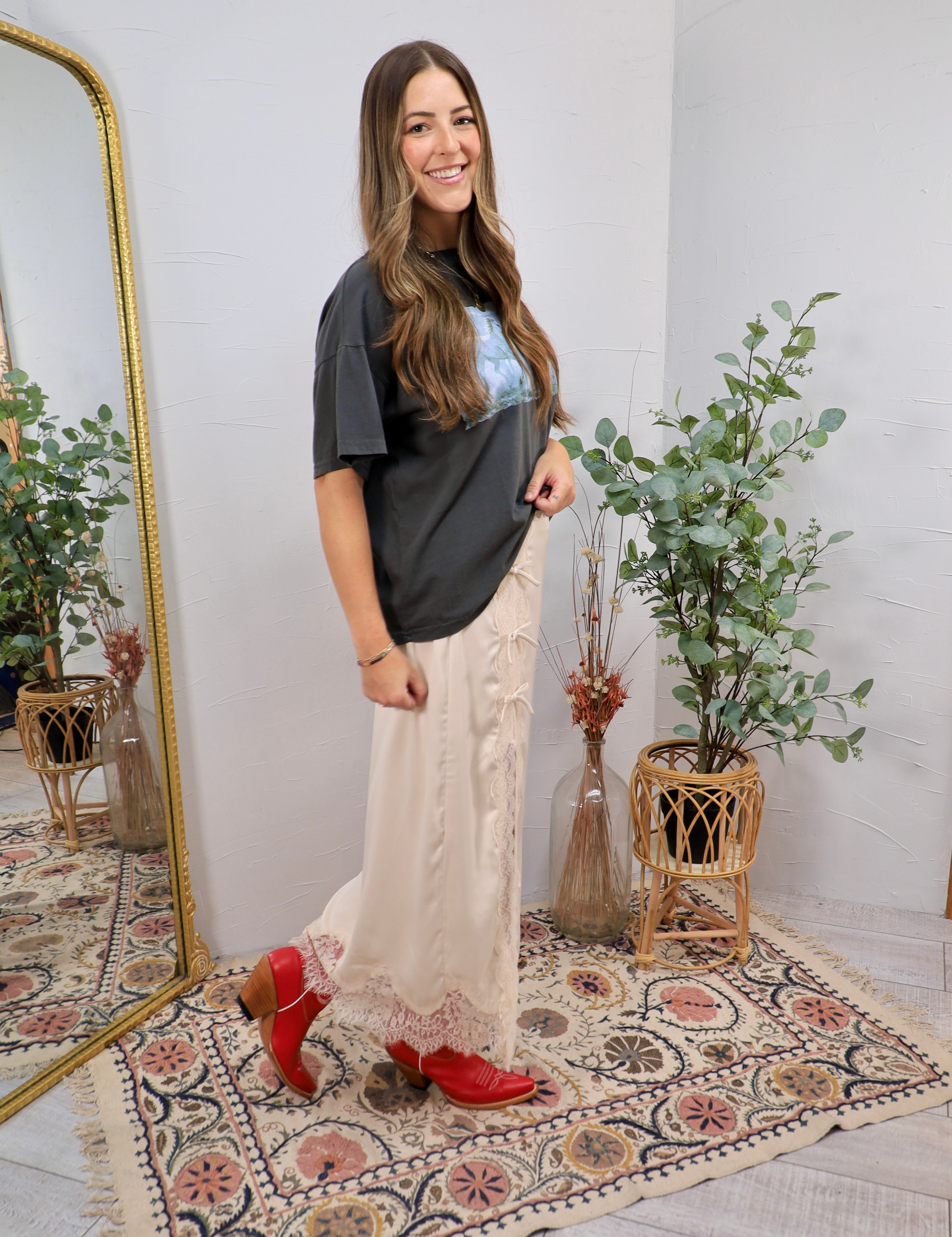 Cream lace midi skirt styled with charcoal graphic tee and red cowboy boots, full length silhouette.