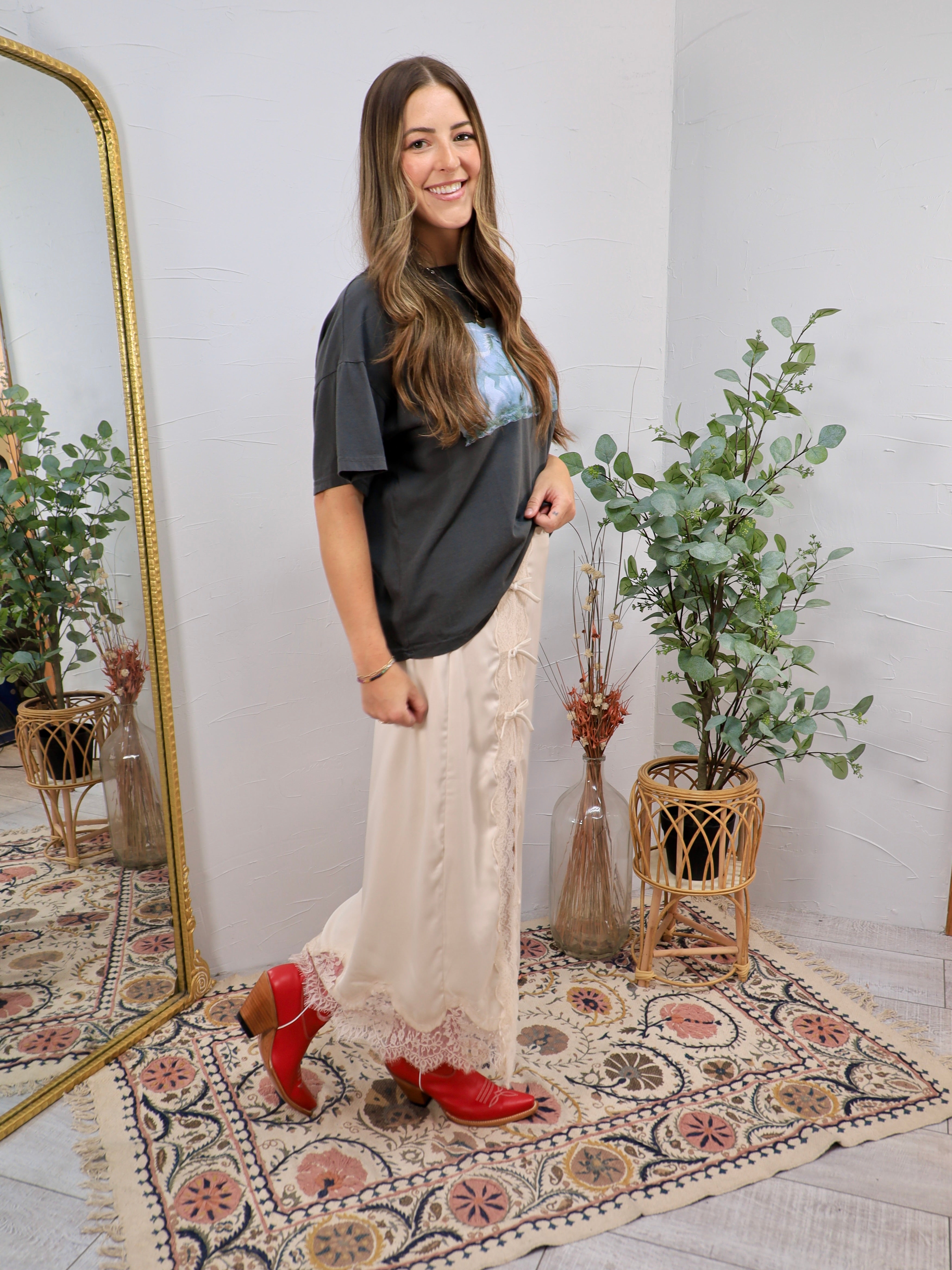 Cream lace midi skirt styled with charcoal graphic tee and red cowboy boots, full length silhouette.