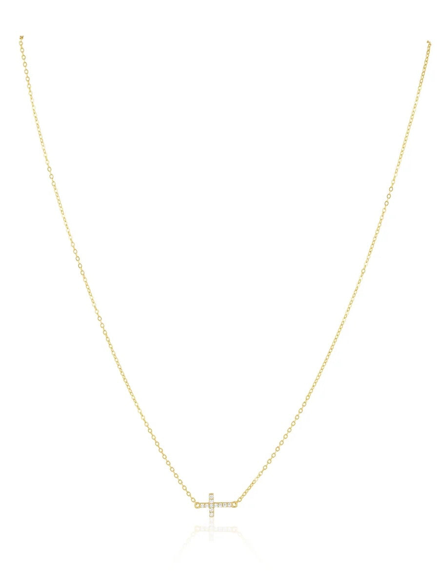 Gold delicate cable chain necklace with pavé crystal sideways cross pendant on white background