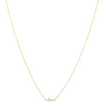 Gold delicate cable chain necklace with pavé crystal sideways cross pendant on white background