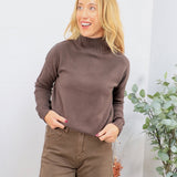 Woman wearing an oversized chocolate brown ribbed mockneck knit sweater with brown wide-leg pants
