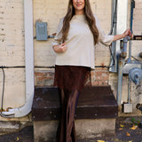 Woman wearing cropped oatmeal sweater top with bell sleeves and lace hem detail
