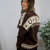 Brown and cream knit cardigan with horseshoe pattern, modeled from the back, showing geometric western-inspired design.