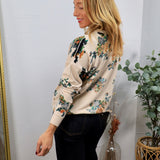 Cream floral cardigan with multicolor blooms, worn over dark jeans, side profile view.