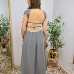 Black and white gingham midi dress with open back straps, flutter sleeves, and lace trim hemline.