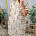Cream shirt dress with red western embroidery grid pattern, featuring cowgirl motifs, styled with red cowboy boots.