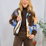 Multicolor sherpa patterned jacket in brown, blue, and tan, styled over dark brown turtleneck and pants.
