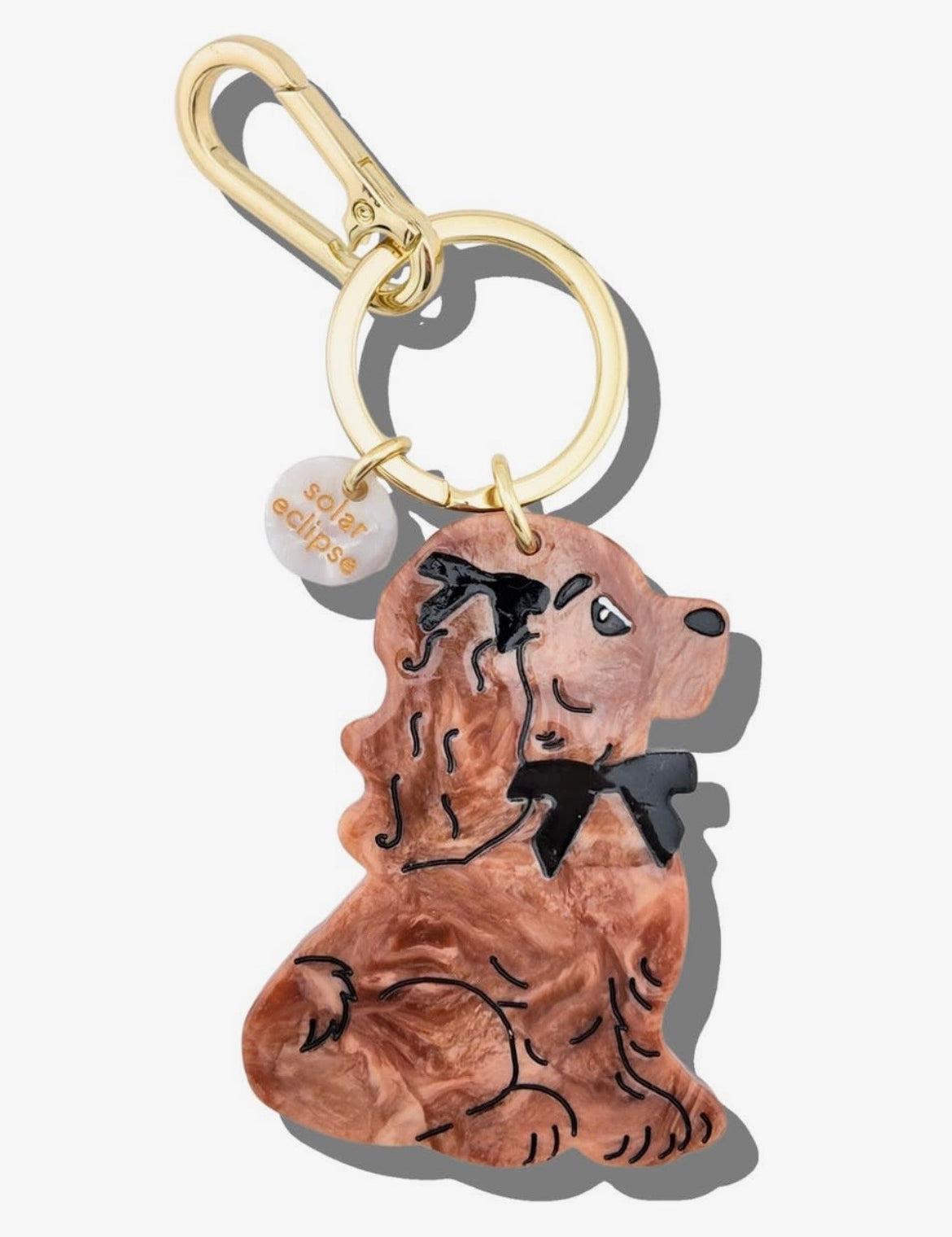 Brown acrylic resin dachshund dog keychain with black bow tie detail and gold carabiner clip.