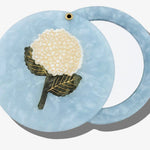Blue marbled acetate compact mirror with white hydrangea flower inlay design and gold accents.