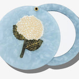 Blue marbled acetate compact mirror with white hydrangea flower inlay design and gold accents.