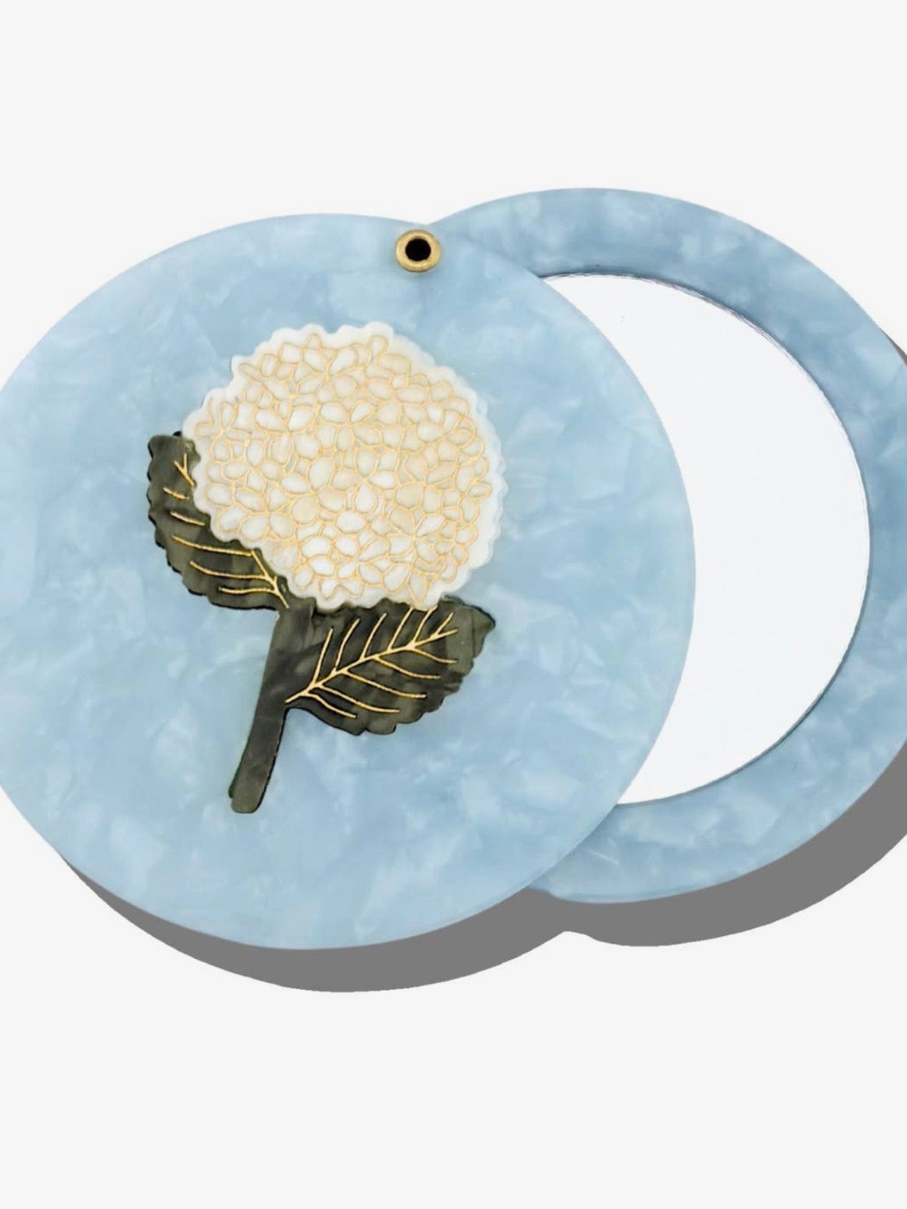 Blue marbled acetate compact mirror with white hydrangea flower inlay design and gold accents.