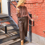 Rust brown printed chiffon tie-neck blouse with long sleeves, styled with chocolate leather culottes and tan boots.