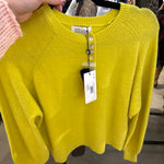 Bright chartreuse yellow Molly Bracken knit sweater with pearl button placket on a black hanger