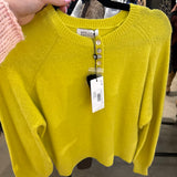 Bright chartreuse yellow Molly Bracken knit sweater with pearl button placket on a black hanger