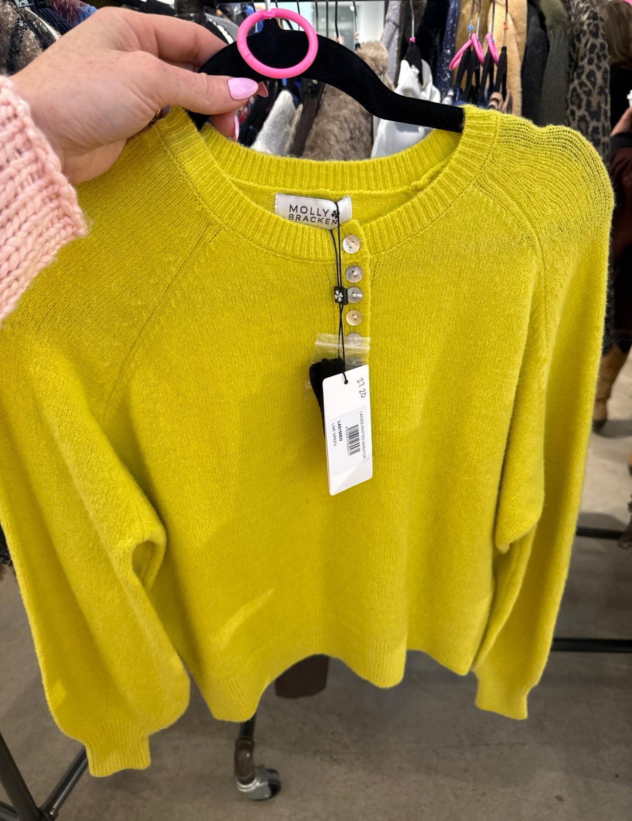 Bright chartreuse yellow Molly Bracken knit sweater with pearl button placket on a black hanger