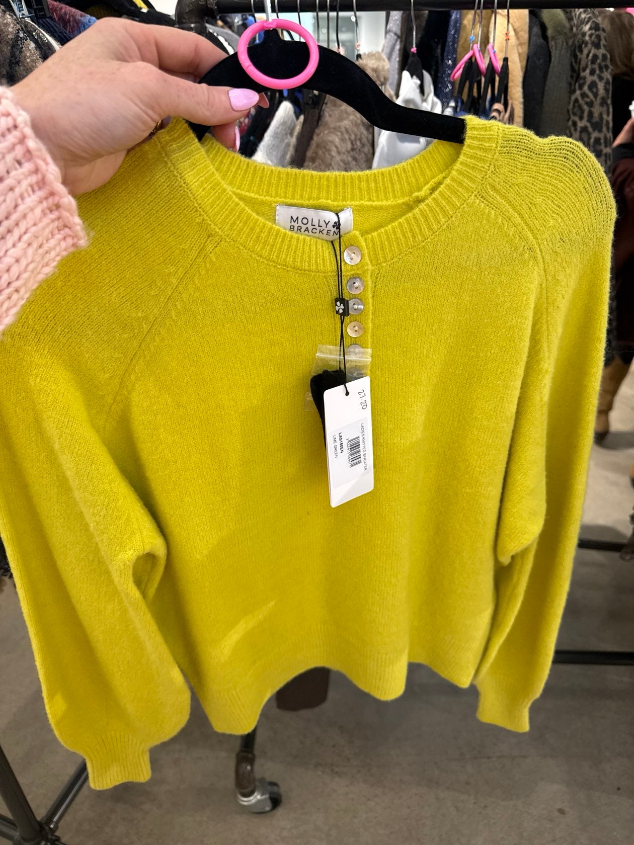 Bright chartreuse yellow Molly Bracken knit sweater with pearl button placket on a black hanger